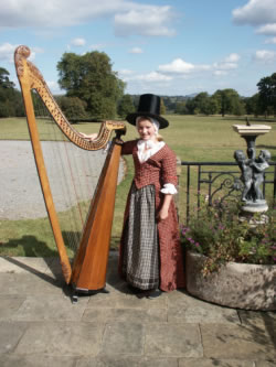 Photograph of Lady Llanover's Great-Great-Great-Great Grand-Daughter wearing her ancestors original costume with a Llanover Triple Harp 